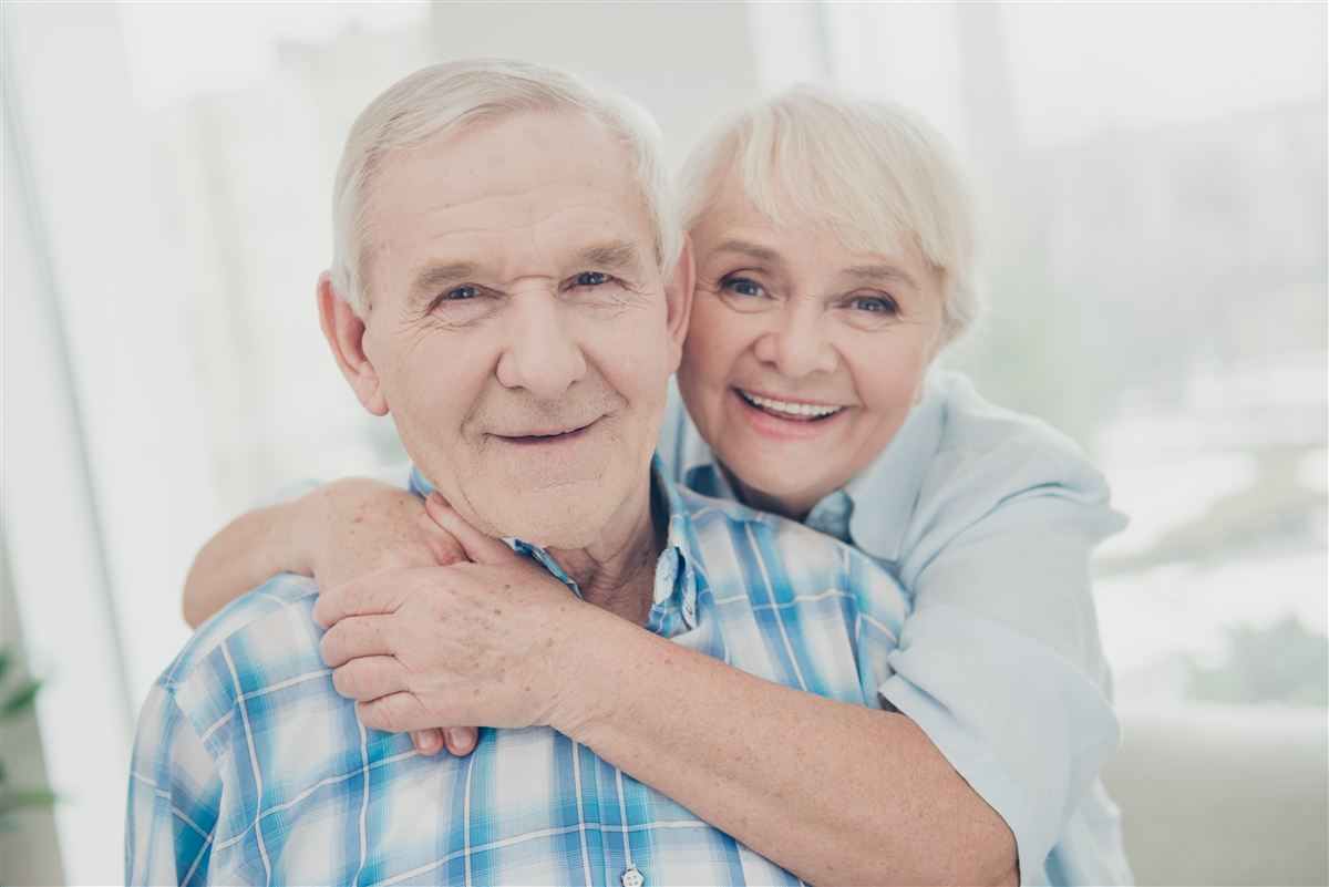 Lächelndes älteres Ehepaar in herzlicher Umarmung