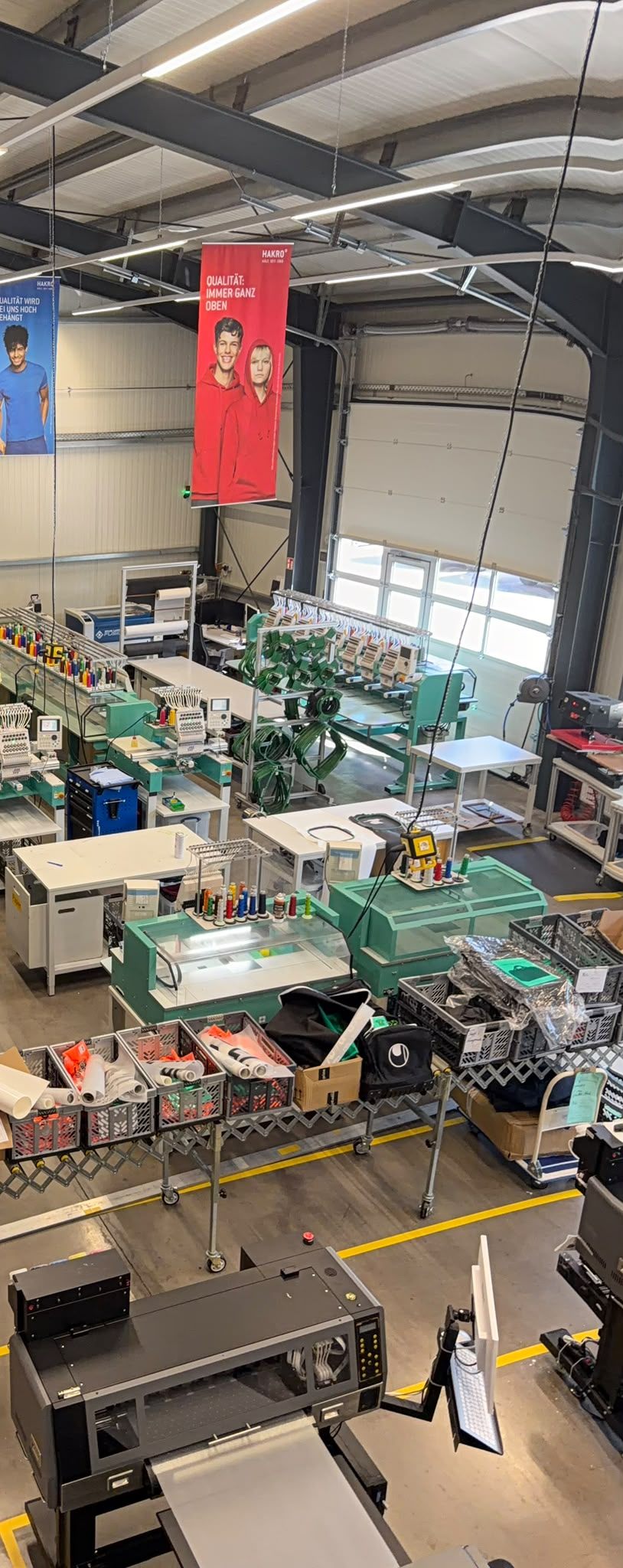 Blick in die Produktion — Stickmaschinen und Materiallager